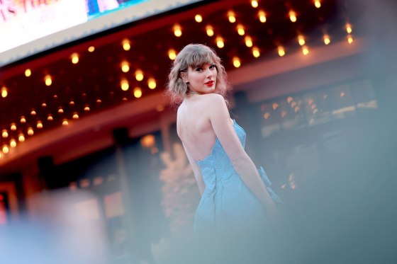 Taylor Swift poses in front of the AMC The Grove 14 Theatre