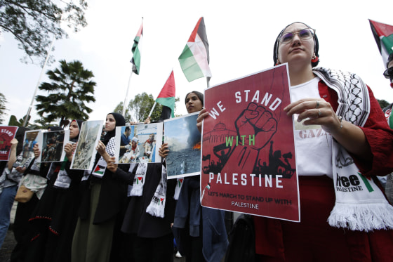 Protesters hold signs during the solidarity rally with