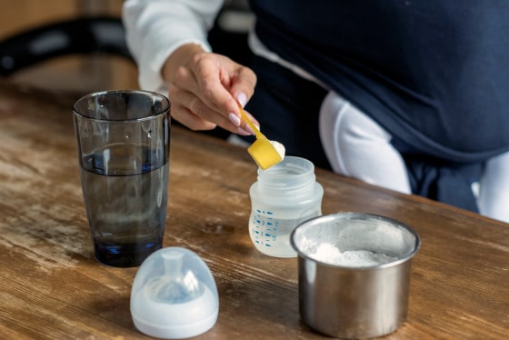 A mother prepares powdered drink for her baby.