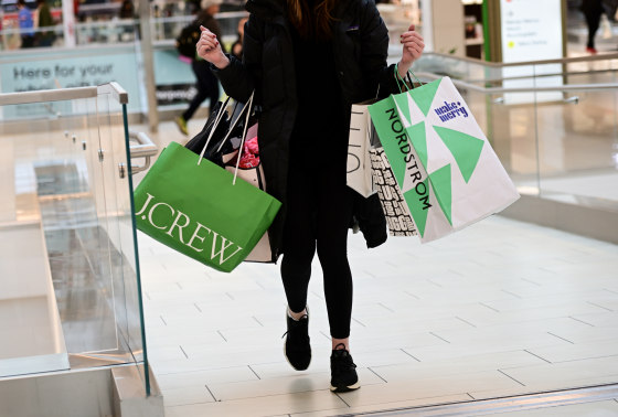 A woman carries bags of merchandise in King of Prussia, Pa. on Dec. 11, 2022.