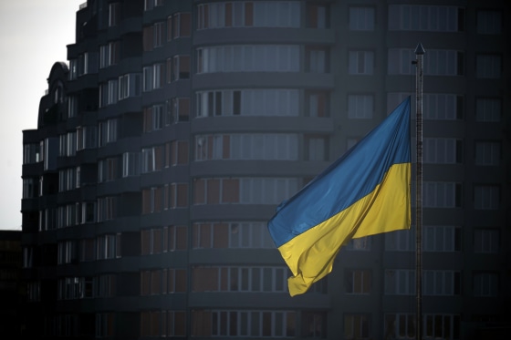 A Ukrainian flag flies in the square in front of the city hall