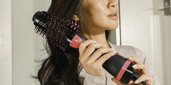 woman using a brush to curl her hair