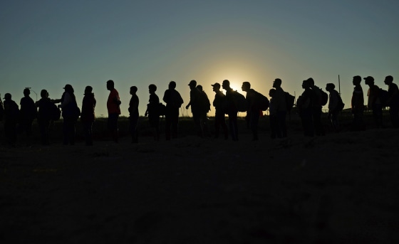 Migrants who crossed the Rio Grande and entered the U.S. from Mexico are lined up for processing by U.S. Customs and Border Protection on Sept. 23, 2023, in Eagle Pass, Texas. 