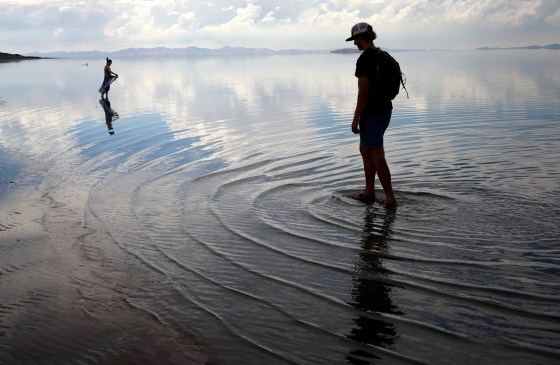 People wade in the waters of the Great Salt Lake at Antelope Island near Syracuse, Utah