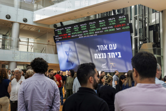 Workers participate in a memorial ceremony to mark a month since the Oct. 7 attack by Hamas militants, inside the Tel Aviv Stock Exchange in Tel Aviv, Israel