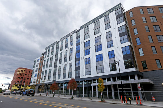 A new apartment building is enclosed in fencing on a Boston street.