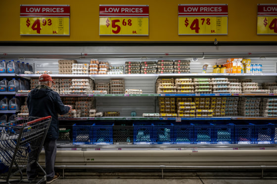 A customer shops for eggs. 