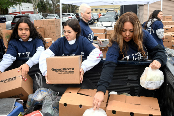 Volunteers load boxes of food into a truck.