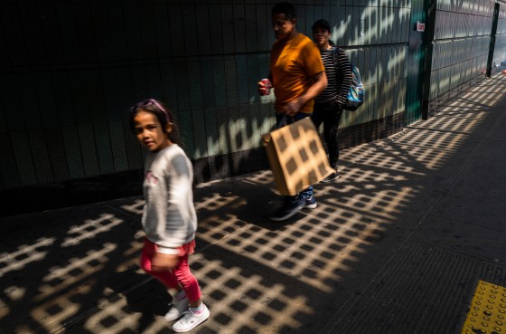 People carrying bags walk in Queens, N.Y.