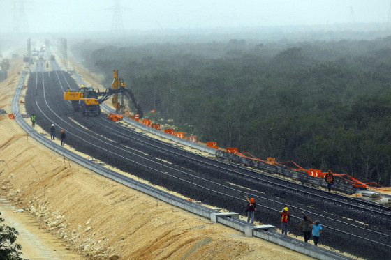 Workers and machinery at a section of the Maya Train in Cancun.