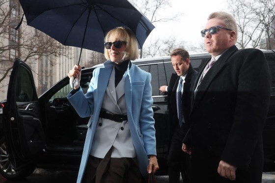 E. Jean Carroll holding an umbrella as she gets out of a car