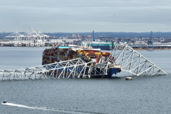 The steel frame of the collapsed Francis Scott Key Bridge sits on top of a container ship, in Baltimore