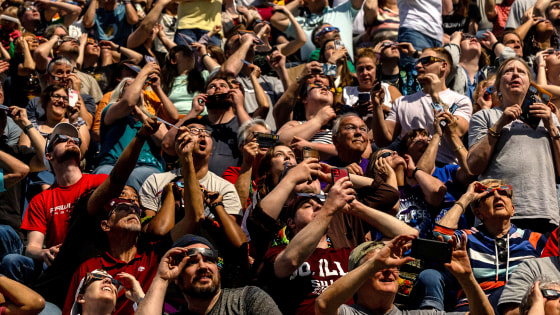 People look at the sky at Saluki Stadium during the total solar eclipse in Carbondale, Illinois