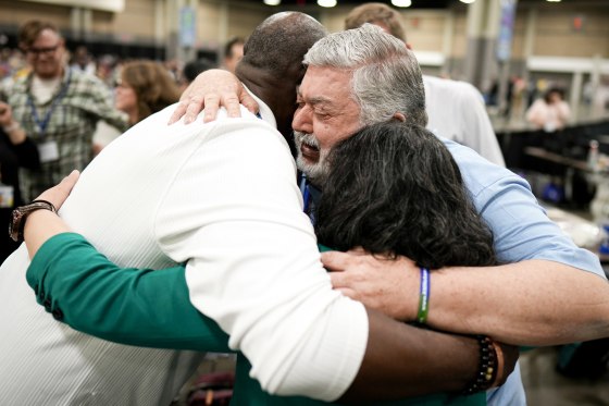 David Meredith, middle, hugs fellow observers.