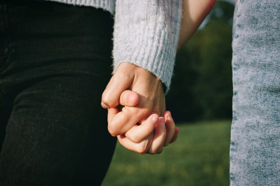 Women holding hands.