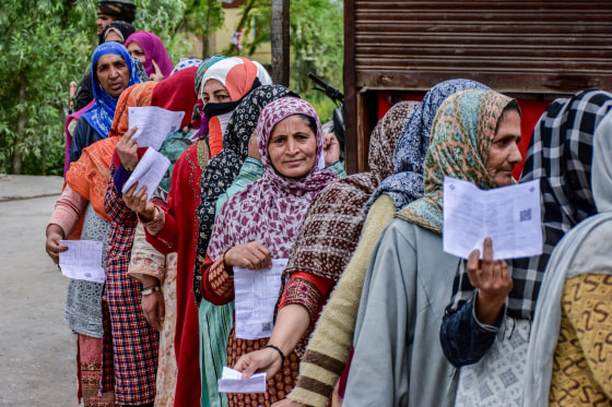 Kashmiri voters queue up to cast their ballots at a polling