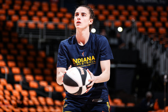 Caitlin Clark holds a basketball on the court