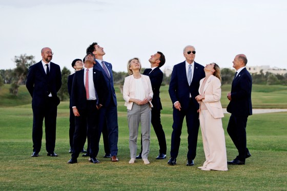 President Joe Biden and other G7 leaders look at the sky during a flag ceremony with paratroopers 