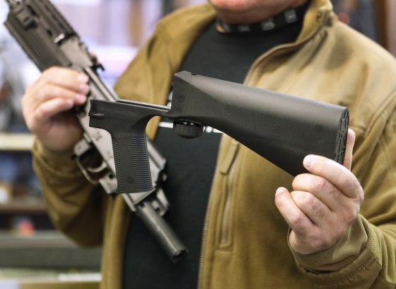 A bump stock device is shown next to a AK-47 semi-automatic rifle at a gun store in Salt Lake City