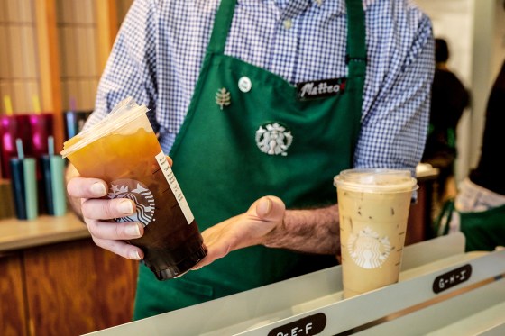 A barista places an iced coffee in the mobile pickup area