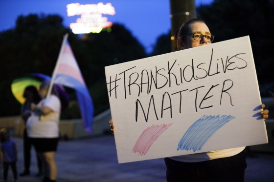 A Transgender rights advocate holds a sign outside the Ohio Statehouse during a rally, in Columbus, Ohio