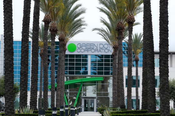 Palm trees outsibe the building with company's name and logo on the facade