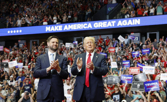  J.D. Vance and Donald Trump stand onstage during a campaign rally at the Van Andel Arena in Grand Rapids, Mich.,