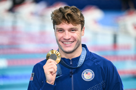 Bobby Finke holds his gold medal while smiling