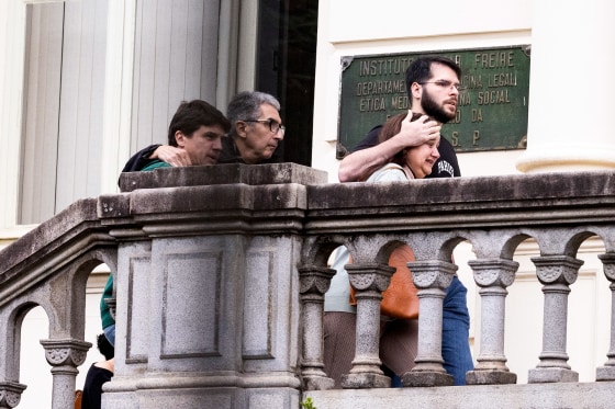 Four people walk up steps outdoors