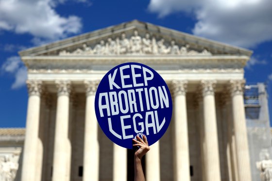 An protester holds a sign that reads, "Keep Abortion Legal"