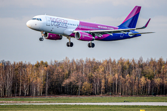 A Wizz Air plane flies above land