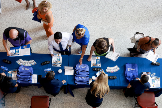 A shot from above of job seekers at an information table.