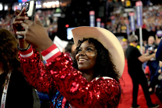 A black woman delegate smiles as she takes a photo at the RNC