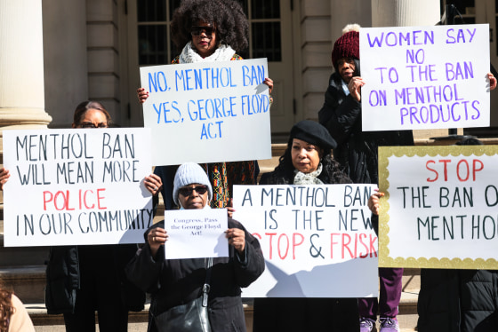 People hold signs against a menthol ban during a rally