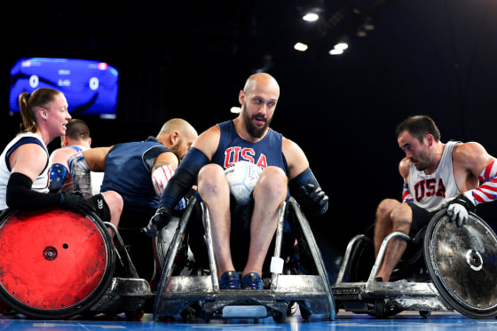 Wheelchair rugby players practice on the court