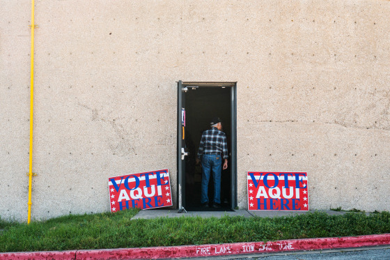 "Vote Here" signs outside library building. 