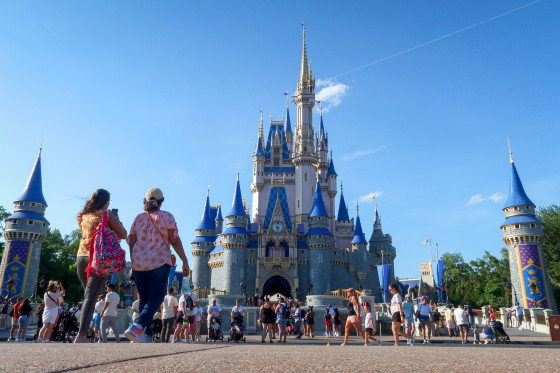 People walk in front of Cinderella's Castle.