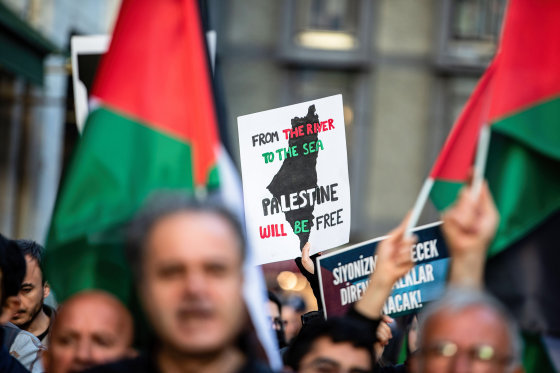 A protester with a sign that  reads "From the river to the sea Palestine will be free" 