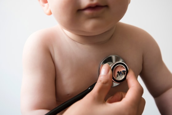 Doctor listening to chest of baby boy with stethoscope