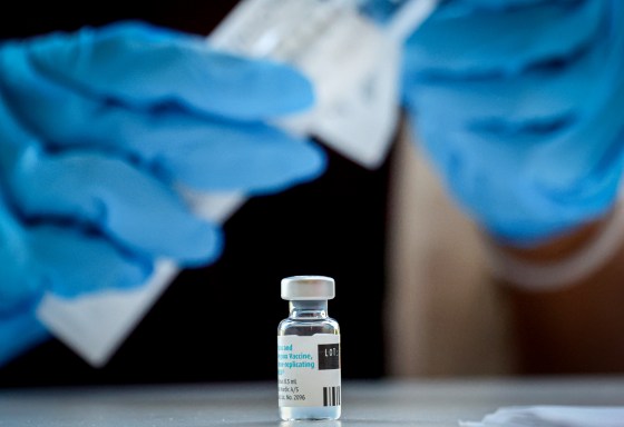 A pharmacist prepares a dose of a vaccine.