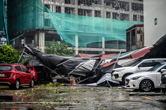 Cars are covered in debris in a parking lot.