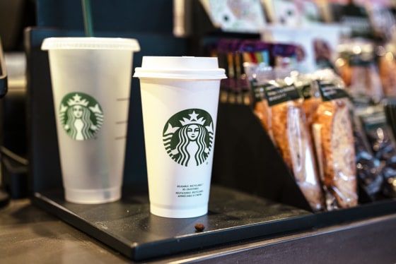 A Starbucks cup seen in a store display with snacks near the cash register