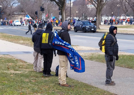 The men the FBI identified as David Walker, with a Trump flag, and Philip Walker, right, on Jan. 6, 2021. They are charged in connection with the assault on a New York Times photographer inside the Capitol building.