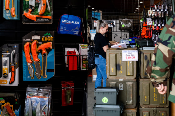 Outdoor safety and camping gear for sale (left) at the Great Lakes Emergency Preparedness Expo in Imlay City, Mich., on Sept. 14; an attendee (right) looks at safety gear and other equipment for sale at a vendor’s booth.