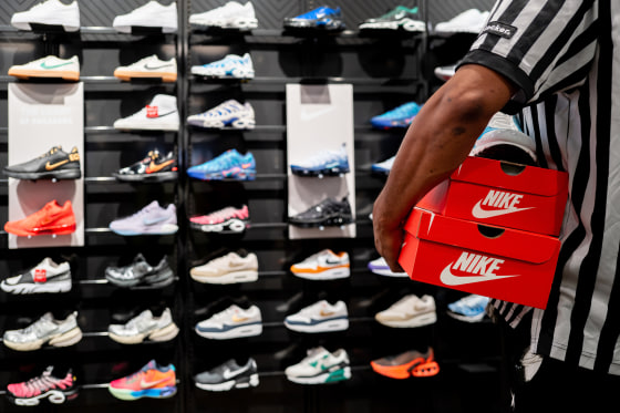 An employee carries shoe boxes at a Foot Locker store.