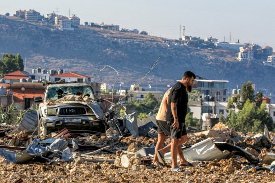 People inspect the site of an Israeli air strike.