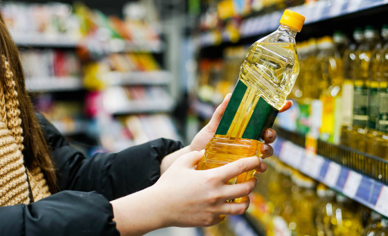 Woman choosing oil in the supermarket.