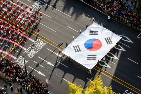 An aerial view of a South Korean flag being carried through a street parade