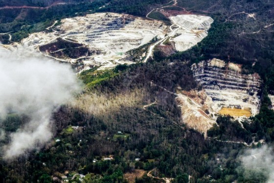 An aerial view of quartz mines, clouds can be seen above the trees