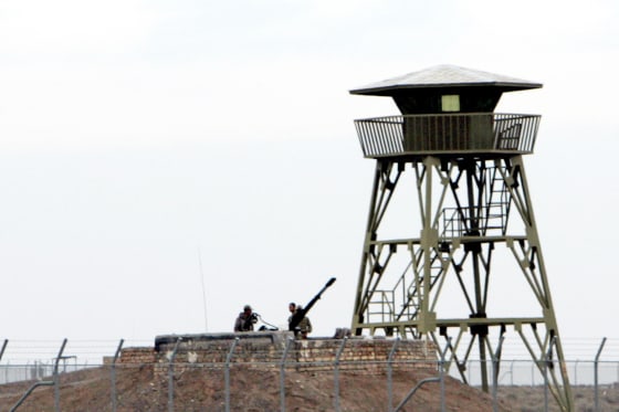 Soldados iraníes hacen guardia en una ametralladora antiaérea dentro de la planta de enriquecimiento de uranio de Natanz